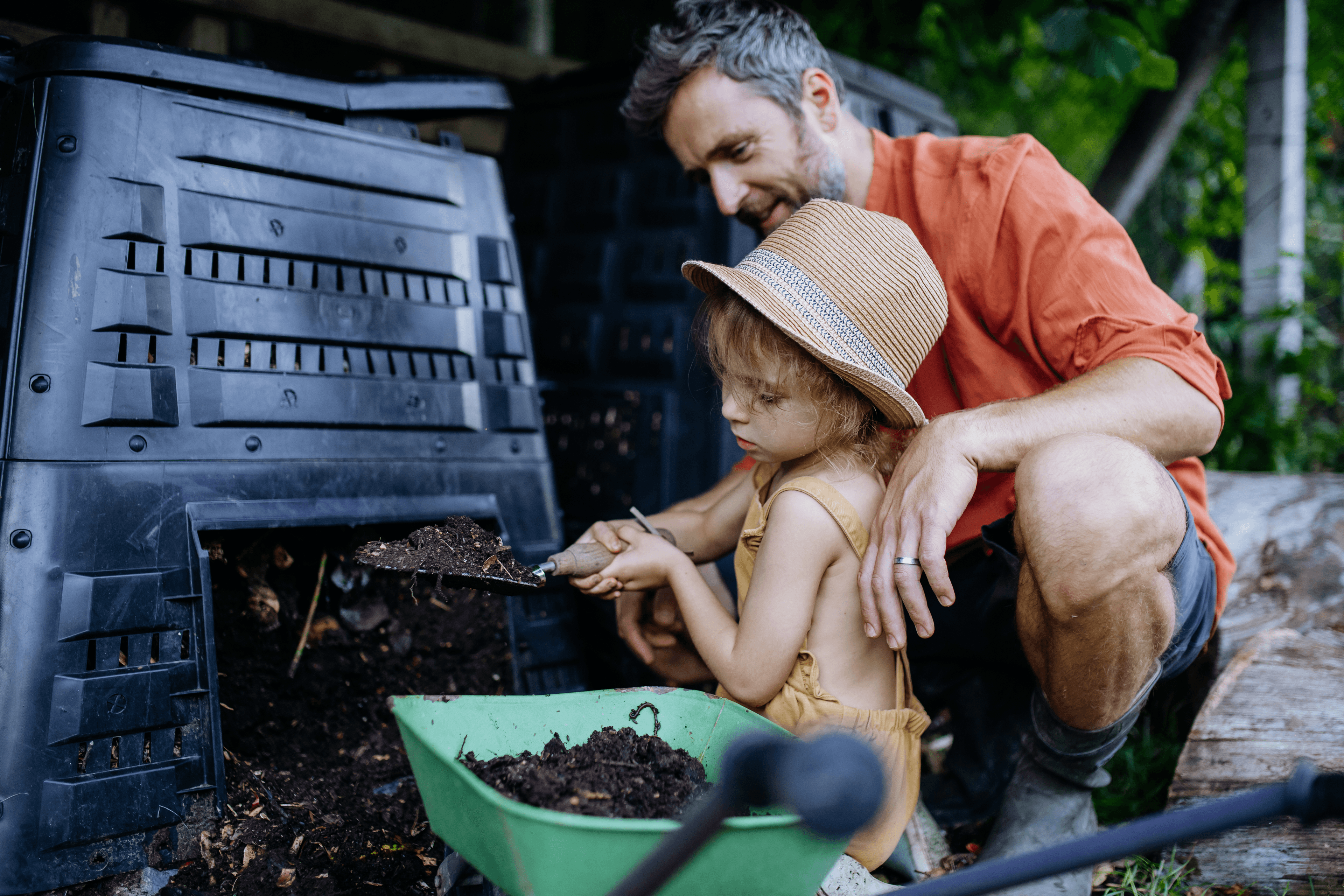 A Father & Daughter using black gold compost from a backyard garden composter